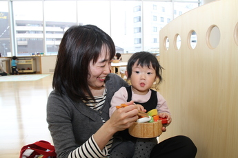 写真：ままごとで遊ぶ母親と女の子