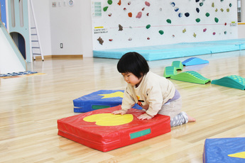 写真：マットで遊んでいる女の子