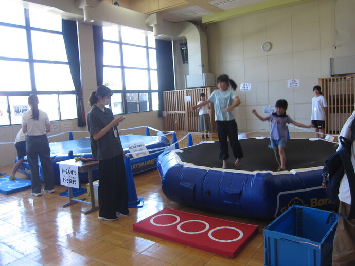 巨大トランポリンに乗ってその上を跳んでいる様子