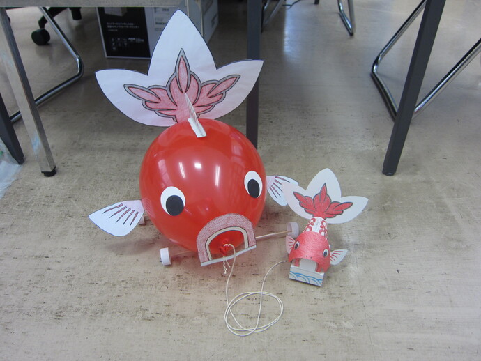 風船でできた金魚台輪と紙でできた金魚台輪が並んでいる様子